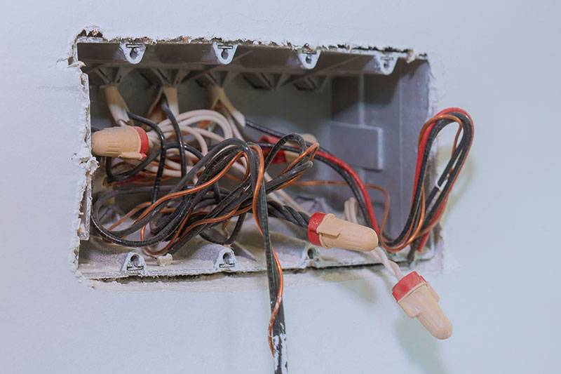 Unfinished electrical mains outlet socket with electrical wires and connector installed in plasterboard drywall for gypsum walls in apartment is under construction Southern Power Electric Fort Myers, FL switch replacement