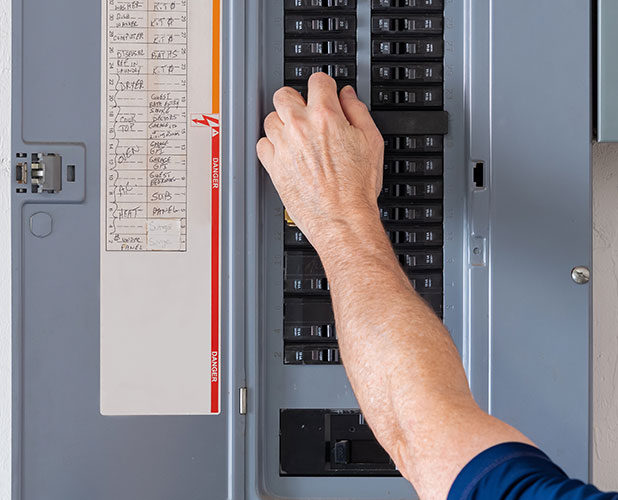 Resetting,Tripped,Breaker,In,Residential,Electricity,Power,Panel.,Male,Electrician panel upgrades